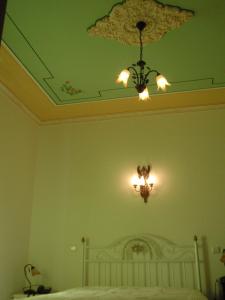 um quarto com um lustre e uma cama branca em "O Viajante" Low Cost Hotel em Estremoz