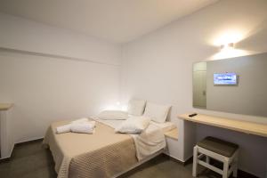 um pequeno quarto com uma cama e um espelho em Hotel Galini Sifnos em Apollonia