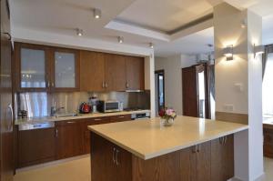 a large kitchen with wooden cabinets and a counter top at Huge Penthouse with Private Pool in Paphos City