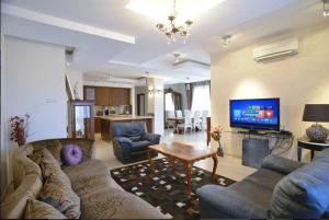 a living room with two couches and a tv at Huge Penthouse with Private Pool in Paphos City