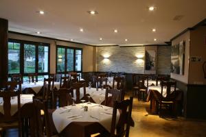 a restaurant with tables and chairs in a room at Hotel Los Molinos in Llanes