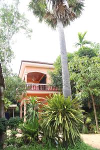 an orange house with a palm tree in front of it at Panhanita Apartment and Villa in Siem Reap