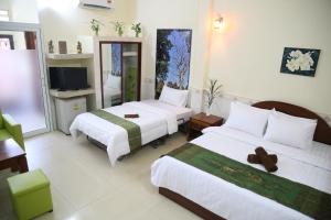 a hotel room with two beds and a television at Panhanita Apartment and Villa in Siem Reap