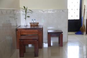 una mesa de madera con 2 sillas y una cesta de botellas de agua en Panhanita Apartment and Villa, en Siem Reap 47 fotos más