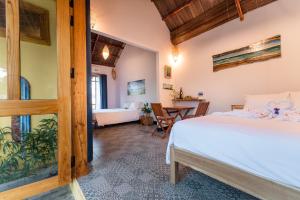a bedroom with a bed and a dining room at La Belle Anbang Homestay in Hoi An