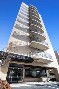 un edificio alto con balcones a un lado. en Hashimoto Park Hotel, en Sagamihara