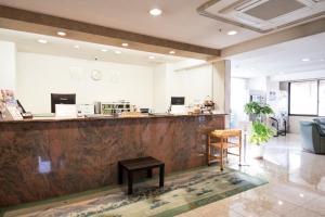 a bar in a lobby with a counter and stools at Hashimoto Park Hotel in Sagamihara