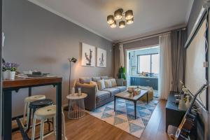 ein Wohnzimmer mit einem Sofa und einem Tisch in der Unterkunft Xi'an Yanta·Yongning Gate· Locals Apartment 00135090 in Xi'an
