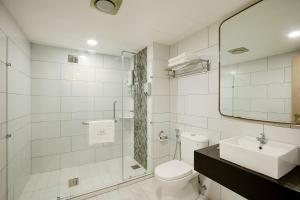 a bathroom with a toilet and a sink and a mirror at MTREE Hotel Nilai - KLIA Airport in Nilai
