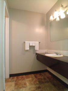 La salle de bains est pourvue d'un lavabo, d'un miroir et de serviettes. dans l'établissement Galaxy Motel, à St. Paul