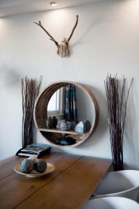 a mirror on a wall above a wooden table at Hightop Apartments Winterberg in Winterberg