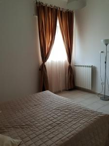 a bedroom with a bed and a window at Grazioso Appartamento Vacanze The Lighthouse in Paola