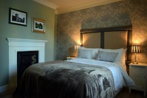 a bedroom with a bed and a fireplace at Greyhound Inn Wilton in Salisbury
