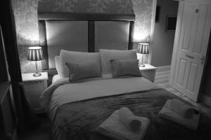 a bedroom with a large bed with towels on it at Greyhound Inn Wilton in Salisbury