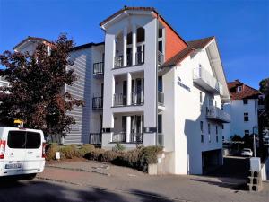 una furgoneta blanca estacionada frente a un edificio en Strandappartement in Binz, en Binz