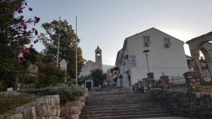 eine Straße mit Treppen, einem Gebäude und einem Uhrturm in der Unterkunft Galeria Nura in Mostar