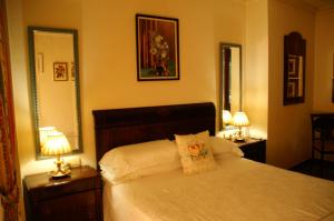 um quarto com uma cama com 2 candeeiros e 2 espelhos em Microclimate Center em Alicante