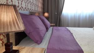 a bedroom with a bed with purple pillows and a window at MANGO Guesthouse in Sighnaghi