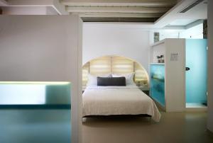 a bedroom with a bed with a wooden headboard at Semeli Hotel Mykonos in M&yacute;konos City