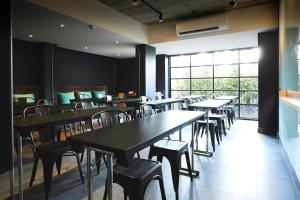 a restaurant with tables and chairs and a large window at Theorie Hotel Sukhumvit by SLH - SHA Extra Plus in Bangna