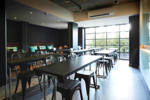 un restaurante con mesas y sillas y una gran ventana en Theorie Hotel Sukhumvit by SLH - SHA Extra Plus en Bangna