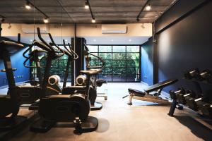 a gym with several tread machines in a room at Theorie Hotel Sukhumvit by Tolani - SHA Extra Plus in Bangna