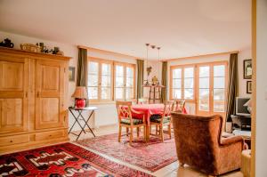 a dining room with a red table and chairs at Apartment Bärhag - GRIWA RENT AG in Grindelwald