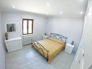 1 Schlafzimmer mit einem Bett, 2 Tischen und einem Spiegel in der Unterkunft La Casetta Magliano De Marsi in Magliano deʼ Marsi