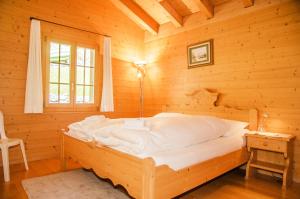a bedroom with a bed in a log cabin at Apartment Chamonix - GRIWA RENT AG in Grindelwald