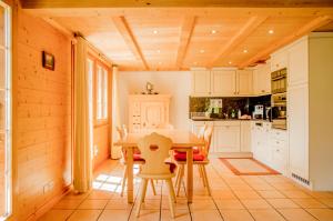 a kitchen with white cabinets and a table and chairs at Apartment Chamonix - GRIWA RENT AG in Grindelwald