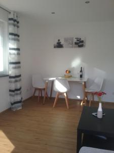 a living room with a table and white chairs at Ferienwohnung Burry in Kapellen-Drusweiler