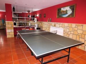 una mesa de ping pong en una habitación con paredes rojas en Finca Canal Vivienda Vacacional en Quintueles