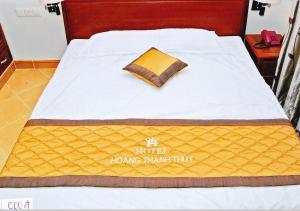 Una cama con una manta amarilla y una almohada. en Hoang Thanh Thuy Hotel 1, en Ho Chi Minh