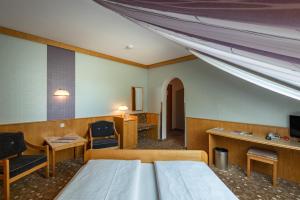 a hospital room with a bed and a desk and chairs at Hotel Gasthof Seeland in Sankt Pölten