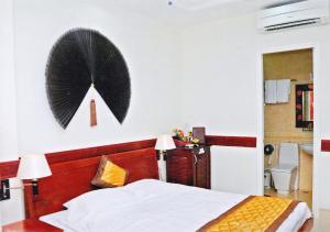 a bedroom with a bed and a wreath on the wall at Hoang Thanh Thuy Hotel 1 in Ho Chi Minh City