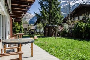 eine Terrasse mit Tisch und Stühlen in einem Hof in der Unterkunft Chalet D in Grindelwald