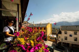 a woman standing on a balcony with flowers at Hôtel Le Grand Tétras in Font-Romeu