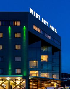 a building with the words west city hotel at night at West City Hotel in Cluj-Napoca