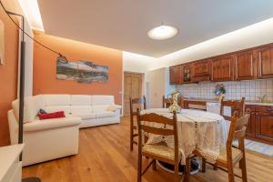 cocina y sala de estar con mesa y sofá en Ampia casa in Cavalese By GoNewLocation, en Cavalese