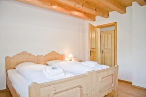 Un dormitorio con una cama grande con sábanas blancas. en Apartment Eiger - GRIWA RENT AG, en Grindelwald
