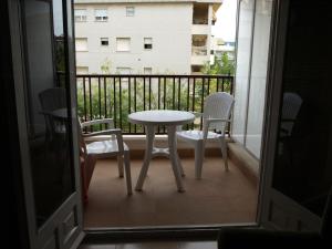 - Balcón con mesa blanca y sillas en Apartaments Geminis, en Cambrils