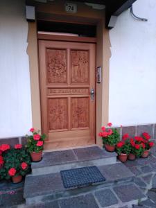 a wooden door with flowers in front of a house at appartamento di Bruno in Moena