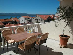 un tavolo in legno e sedie sul balcone. di Apartments & Rooms Luna a Bol