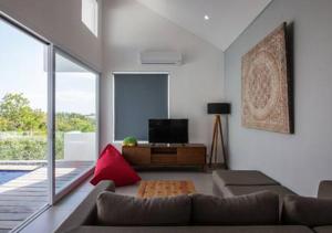 a living room with a couch and a television at Villa Omah Bali in Uluwatu