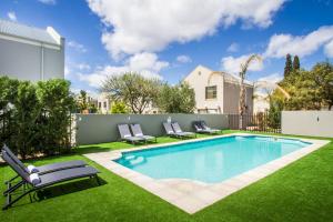 a backyard with a swimming pool and green grass at El Dorado 65 Luxury Self Catering in Oudtshoorn