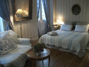 a bedroom with two beds and a couch at Au Fil de l'Aulne in Châteauneuf-du-Faou