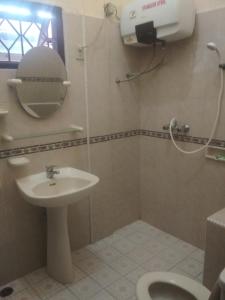 a bathroom with a sink and a toilet and a mirror at Sapo Karo Rest House in Berastagi