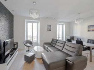 a living room with a couch and a table at Welkeys - Delille Apartment in Nice