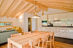 een keuken en eetkamer met een houten tafel en stoelen bij Chalet Eigerlicht - GRIWA RENT AG in Grindelwald