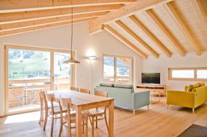 una sala da pranzo e un soggiorno con tavolo e sedie. di Chalet Eigerlicht - GRIWA RENT AG a Grindelwald